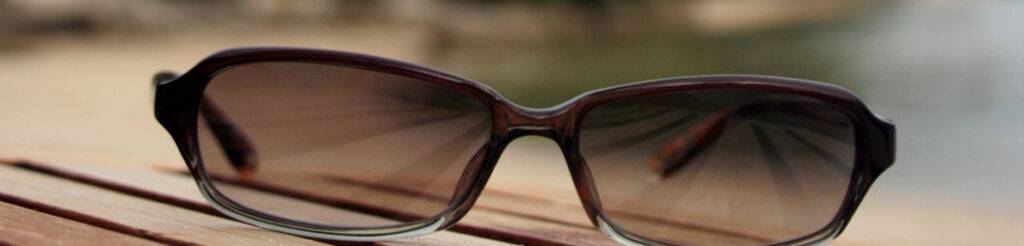 A pair of prescription glasses with photochromic lenses during the darkening process.